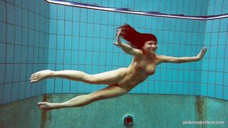 In the indoor pool, a stunning girl swims
