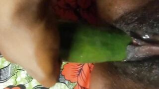 Ebony girl plays with cucumber