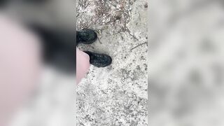 Dirty sneakers stepping on pine cones in the park