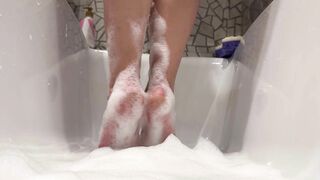 Women's feet playing in the foam. Lick my toes and heels right now.